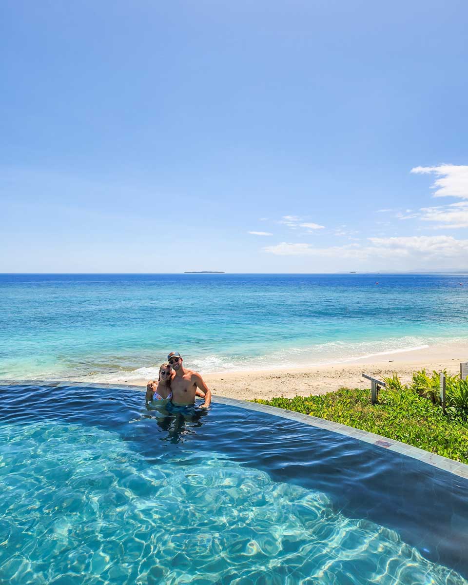 Bailey and Daniel pose for a photo in the infinity pool at Malamala Beach Club in Fiji