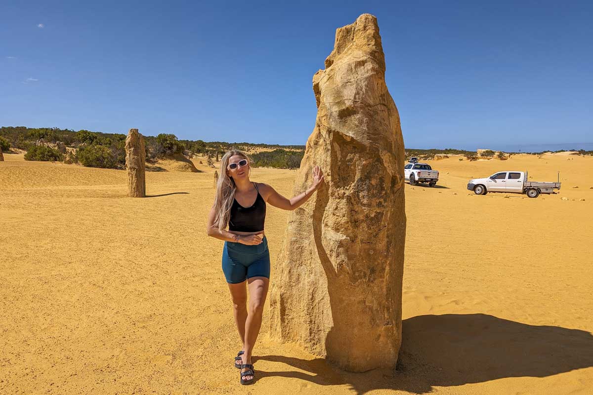 Bailey stands by a pinnacle with trucks in the background australia
