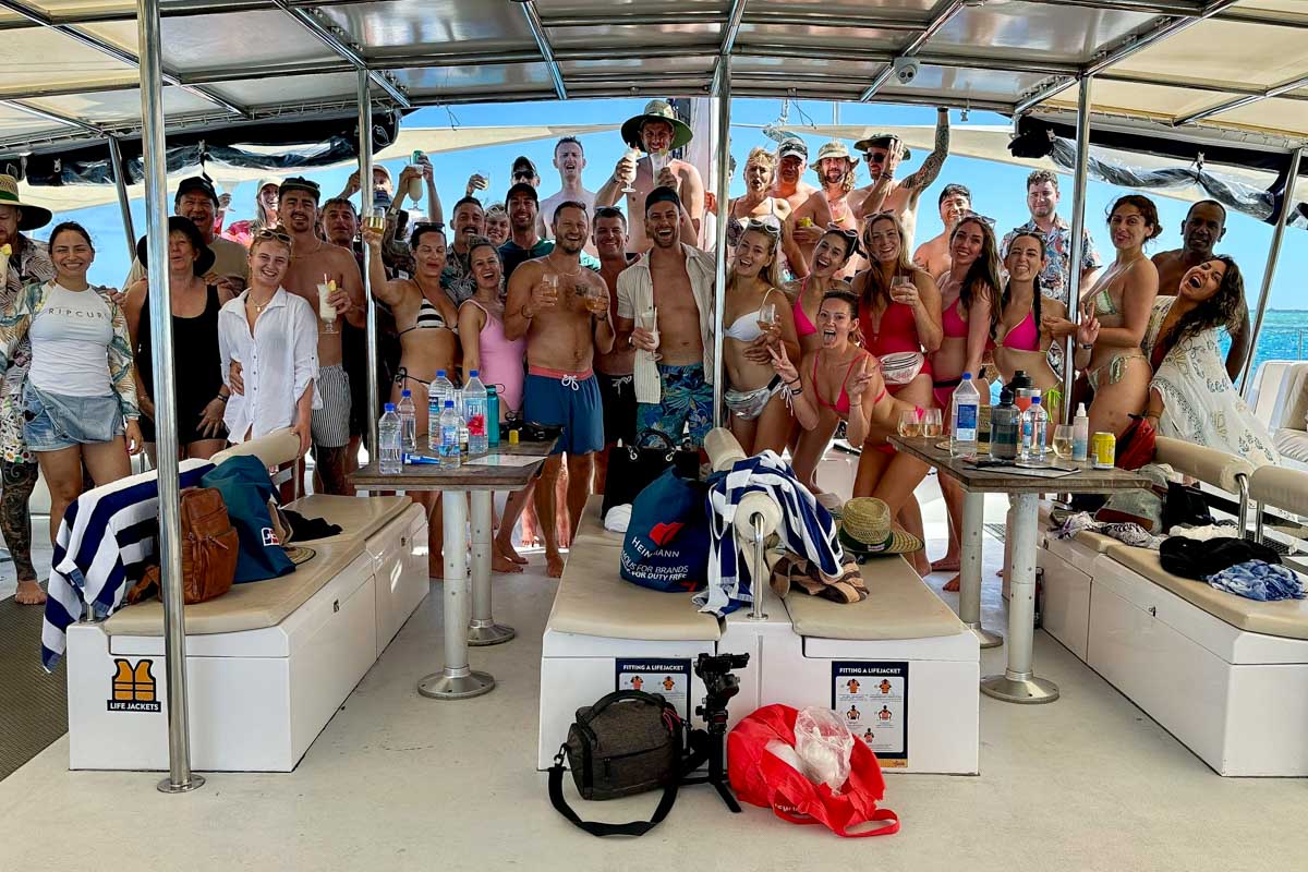 Everyone aboard the Sabre catamaran cruise posing for a photo and smiling Fiji