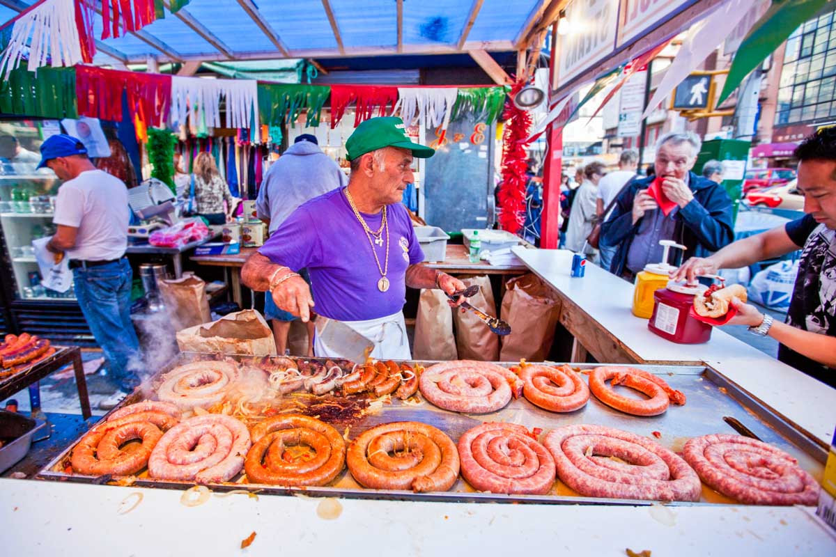 Italian man cooks sausages at the The Feast of San Gennaro in NYC