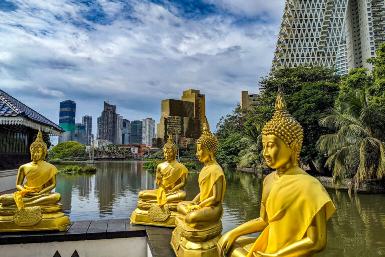 Meditating golden Buddha statues surrounding the floating Gangaramaya Temple Colombo, Sri Lanka