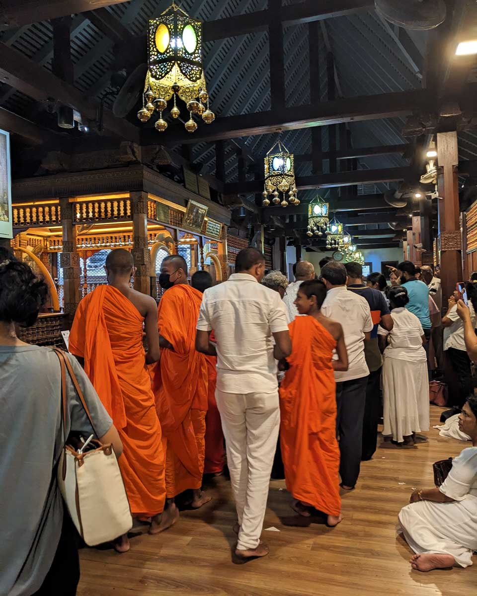 Monks lined up to make offerings at the Sacred Tooth Temple Kandy Sri Lanka