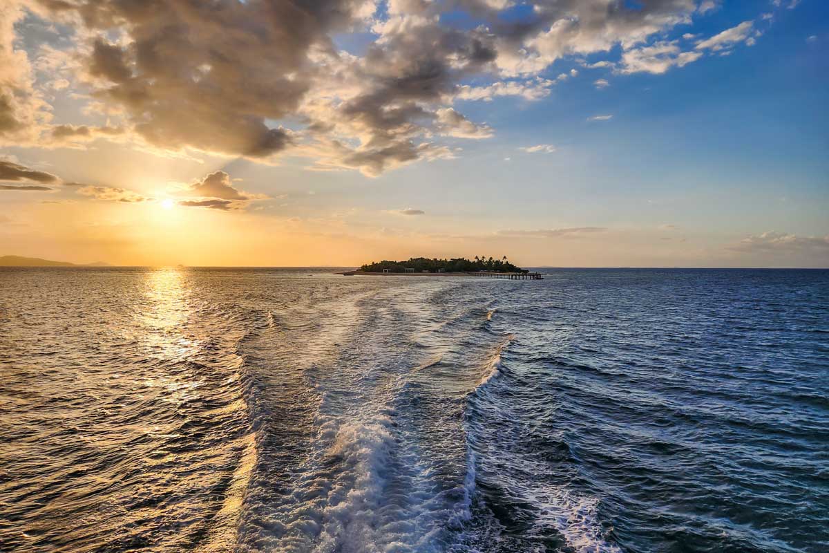 Sunsets behind an island on a sunset and cultural cruise in Fiji
