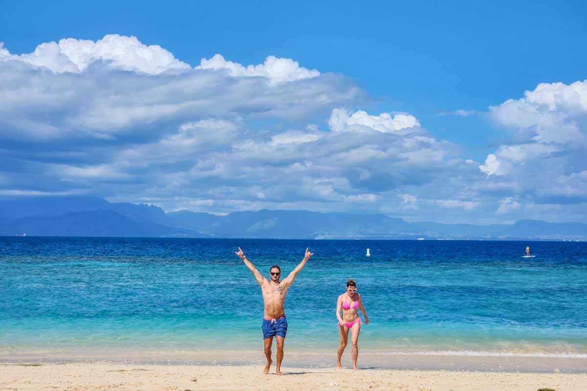 Two people walk along the beach on South Sea Island, Fiji