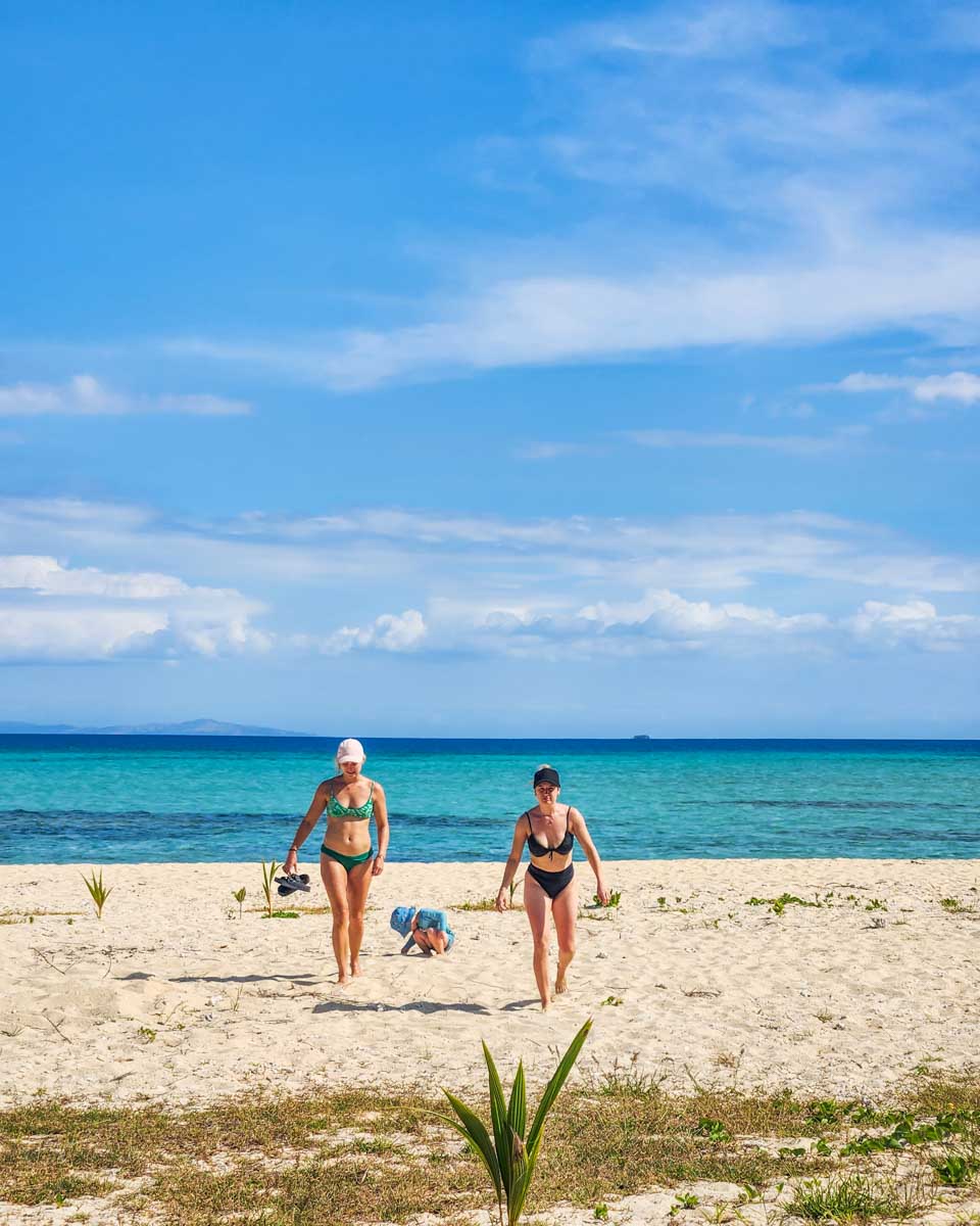 Two people walk on the beach at Nadi Tivua Island in Fiji