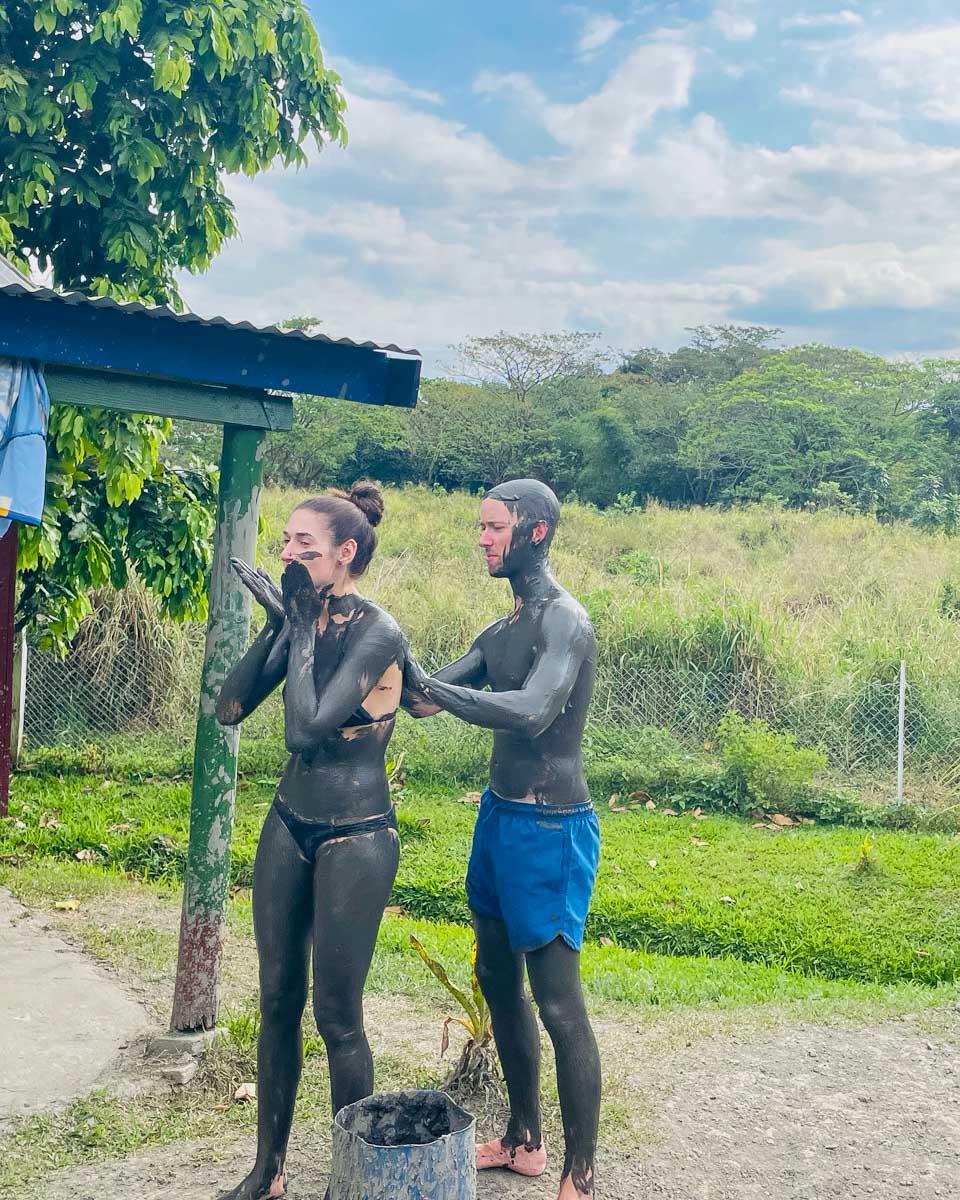 A couple putting mud on eachother at sabeto mud pools fiji