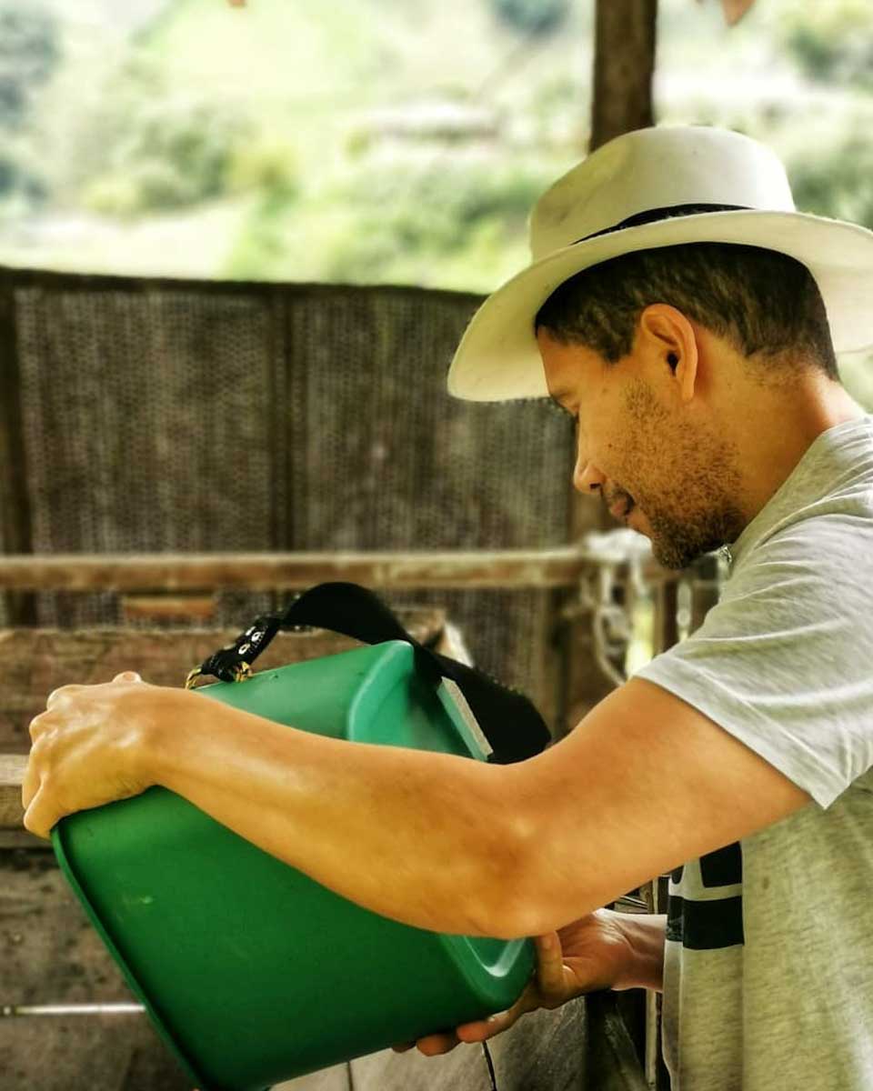 A man pours Coffee beans into a processore in Jardin Colombia with Medellin Day Trips
