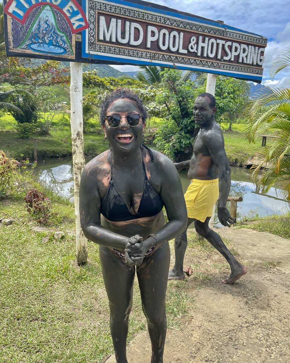A woman smiles at tifajek mud pool hot spring fiji