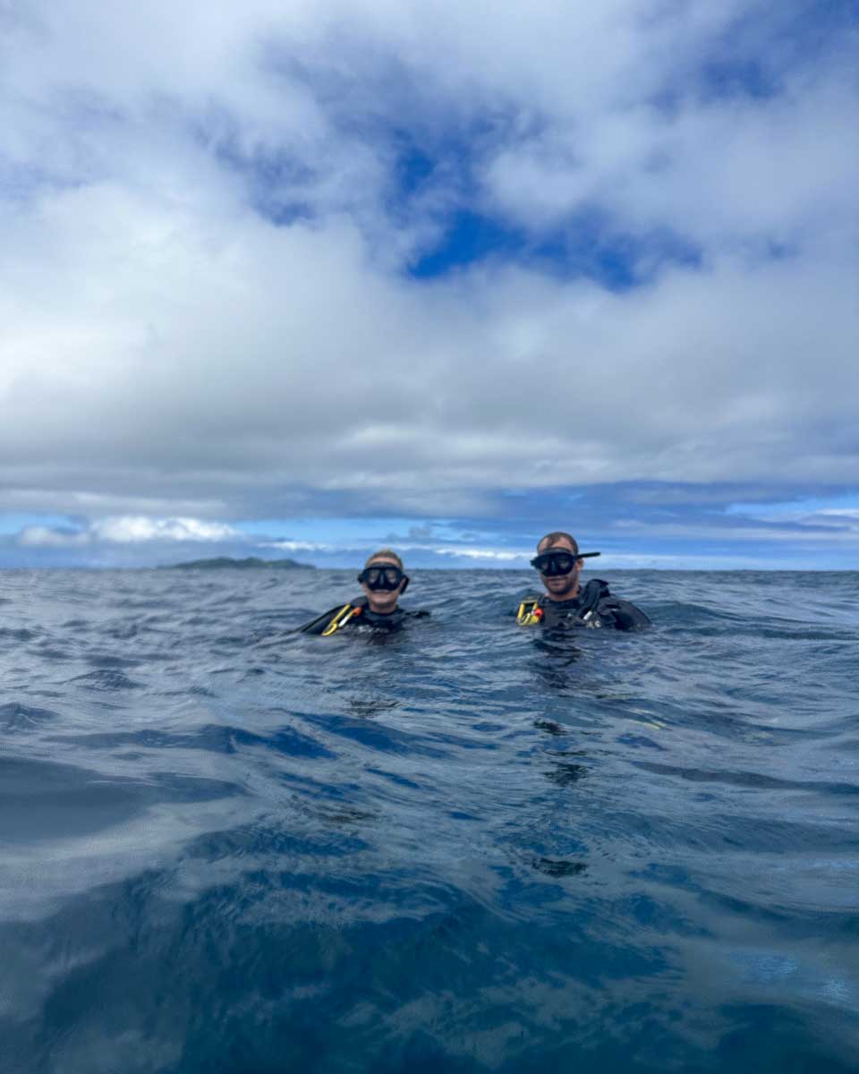 Bailey and Daniel smile as they surface during a shark dive fiji