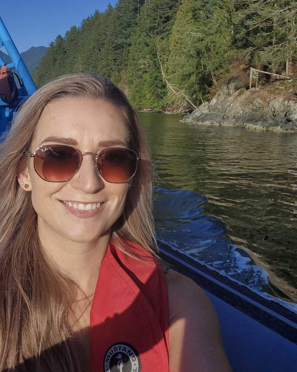 Bailey smiles aboard the zodiac boat with stanly island in tthe background Vancouver, Canada