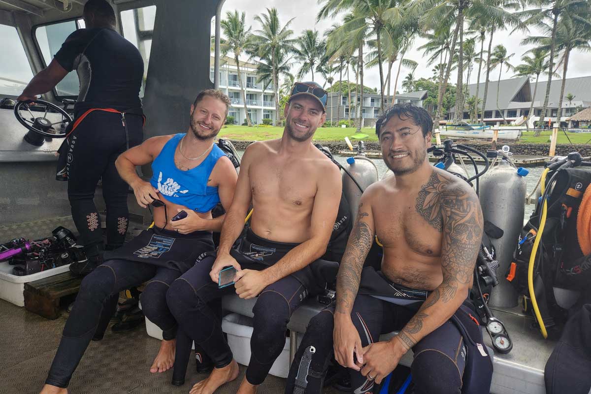 Daniel and friends smile in their diving gear during a shark dive fiji