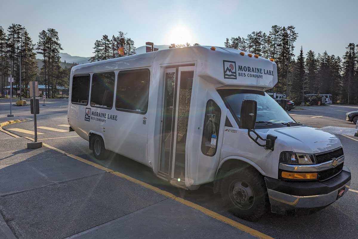The Moraine Lake Bus Company Shuttle with the sun behind it canada