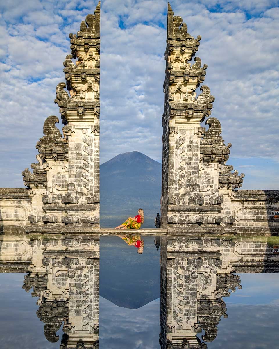 Bailey at the gate to Lempuyang temple with the mountain in the distance on the instagram tour bali