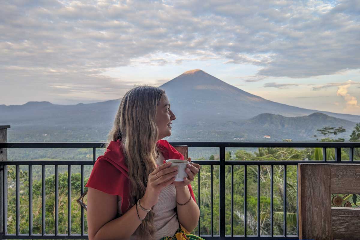 Bailey enjoys a cup of coffee with Mount Lempuyang in the distance on the instagram tour bali