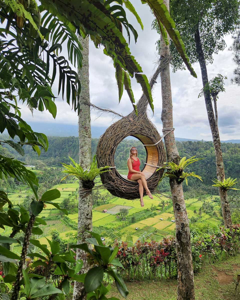 Bailey sits in a suspended chair at the jungle swing in Bali on the instagram tour
