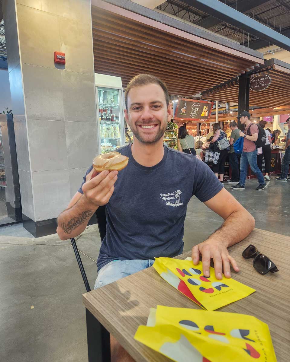 Daniel eats a doughnut in Calgary Farmers’ Market