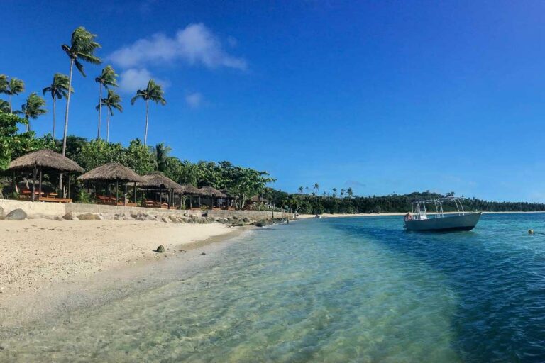 A boat sits at a beach near a resort in the Yasawa Islands Fiji