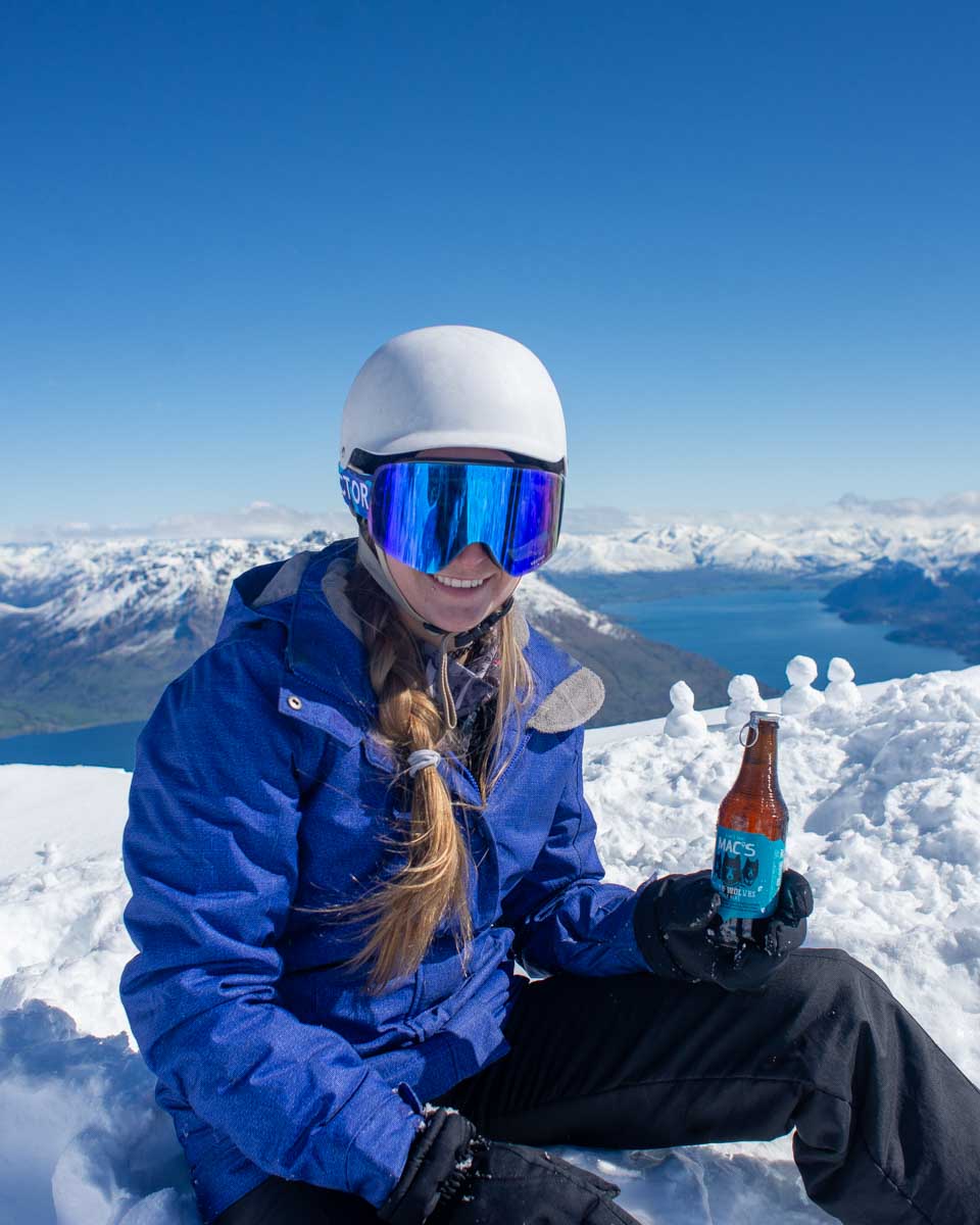 Bailey-at-the-Remarkables-ski-area-on-a-mountain-with-a-beer-New-Zealand