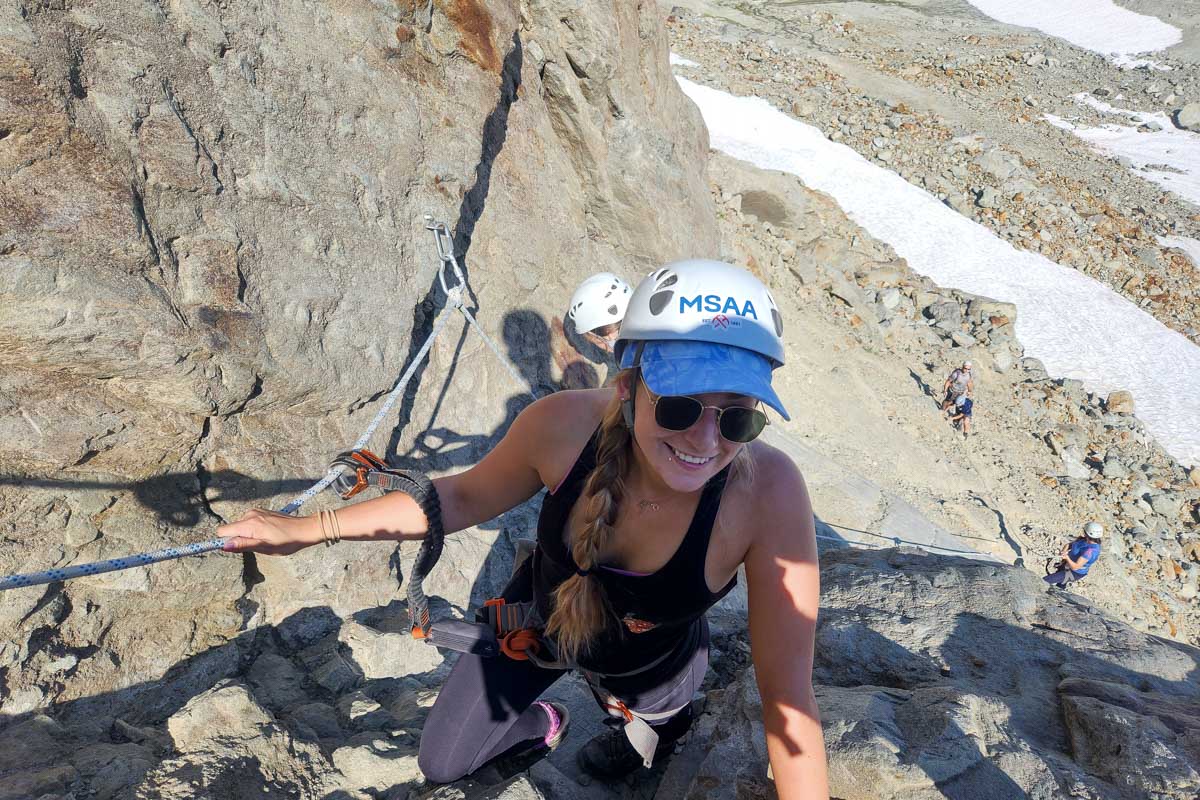Bailey-climbing-up-rocks-in-her-gear-during-Via-Ferrata-Whistler-Canada through get your guide