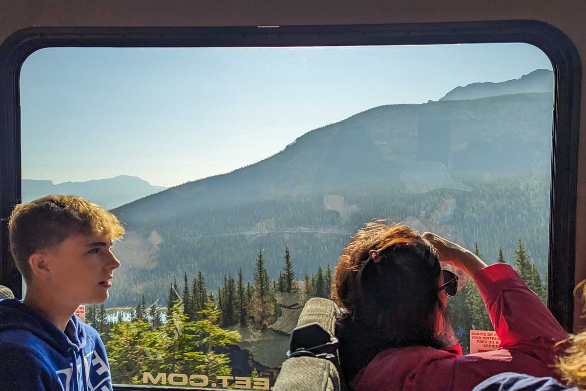 People look out a window on a shuttle beetween Calgary and Banff