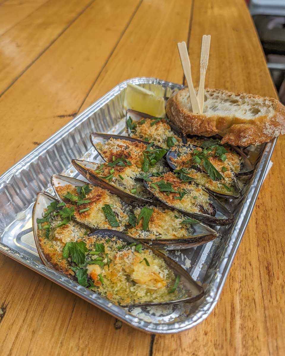 Tasting mussels on a food tour inside the Queen Victoria Market in Melbourne Australia