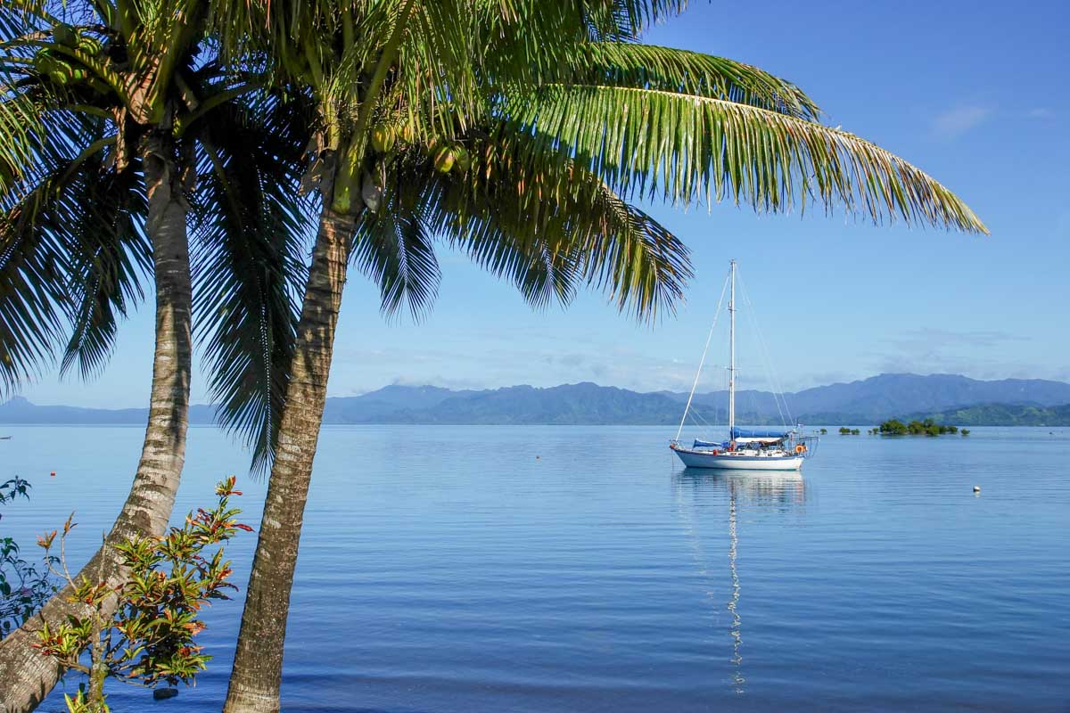 A boat anchored off an island in Fiji on a multi day cruise