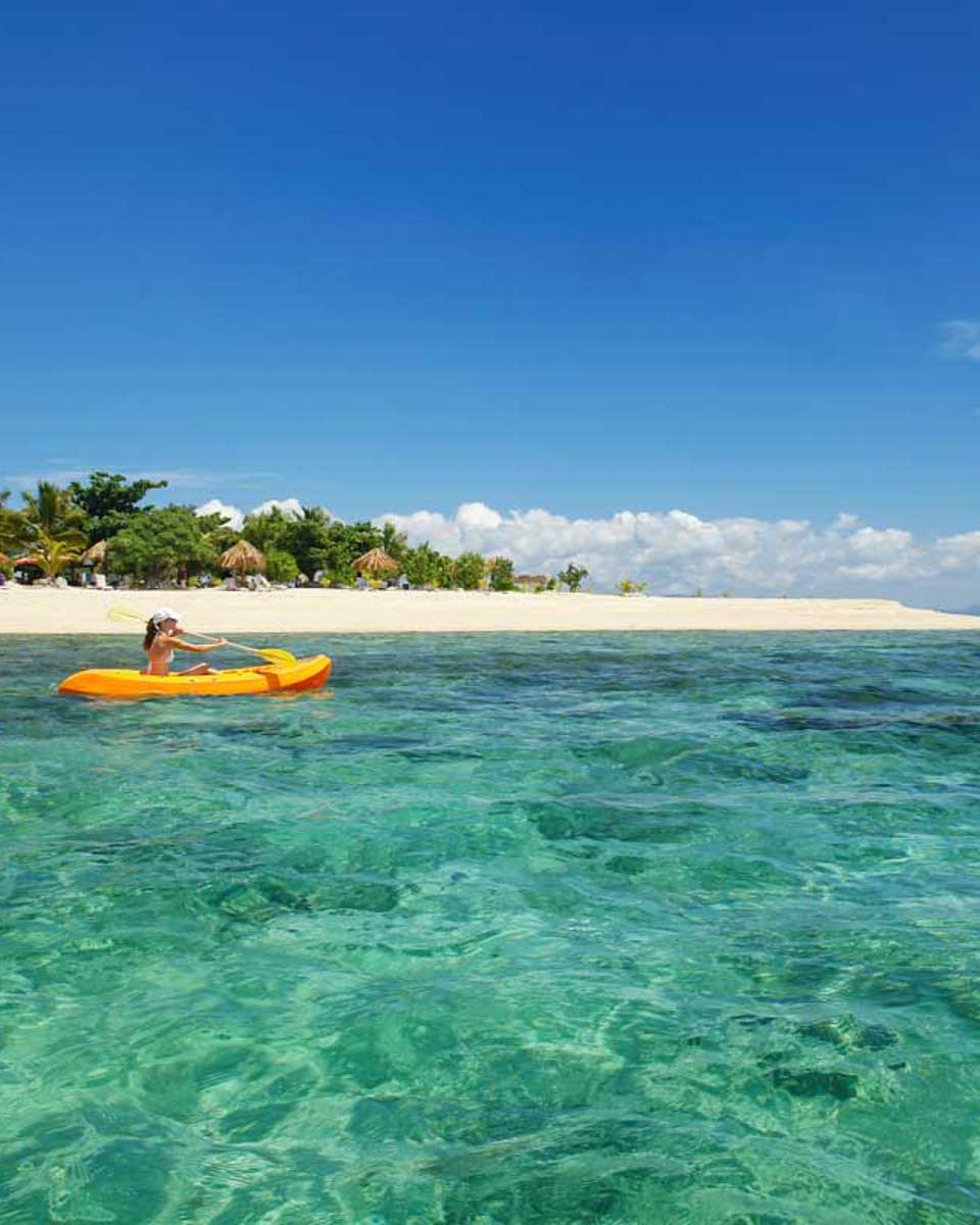 A lady kayaks at South Sea Island Fiji on a multi day cruise