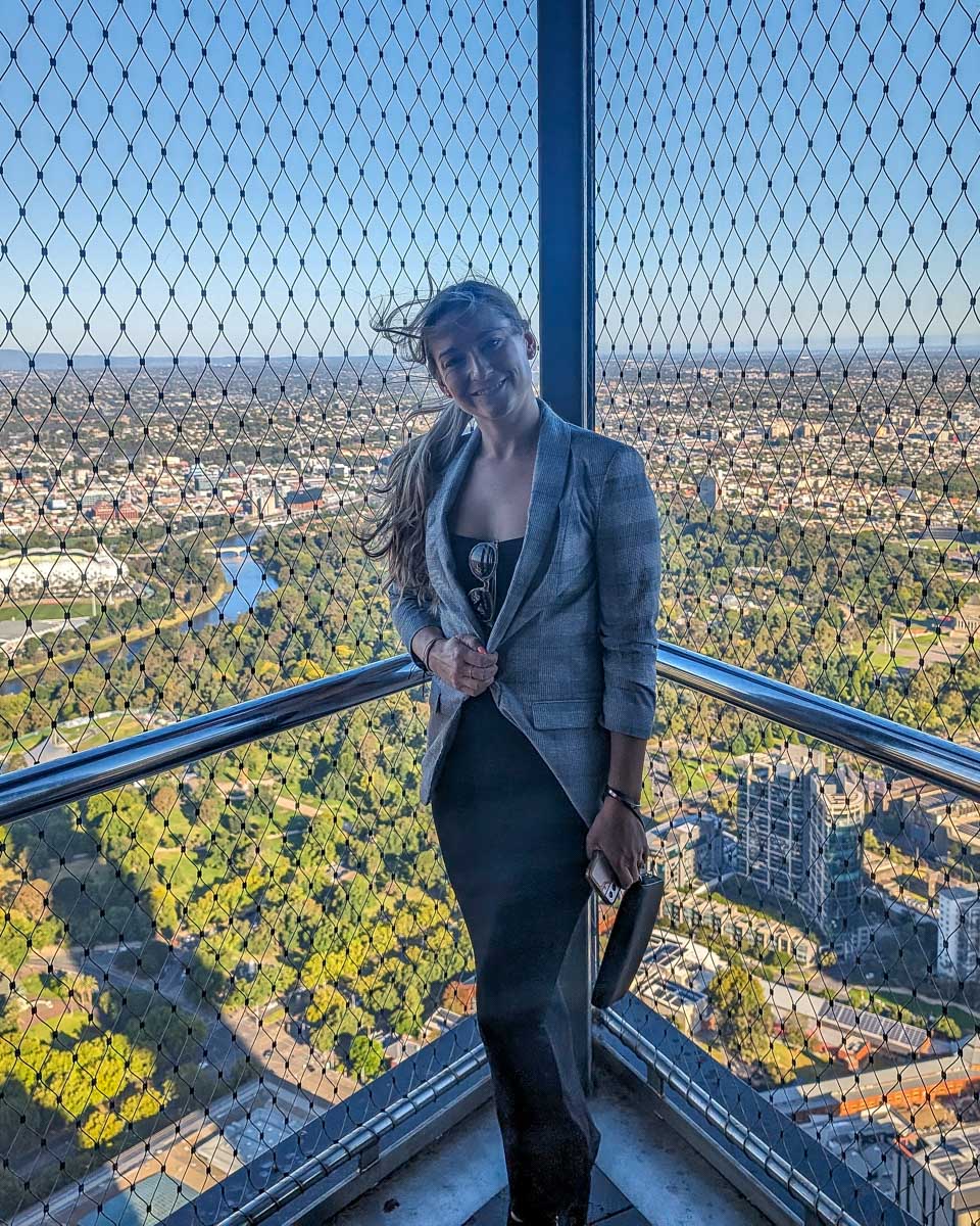 Bailey outside of the melbourne skydeck with a fence behind her
