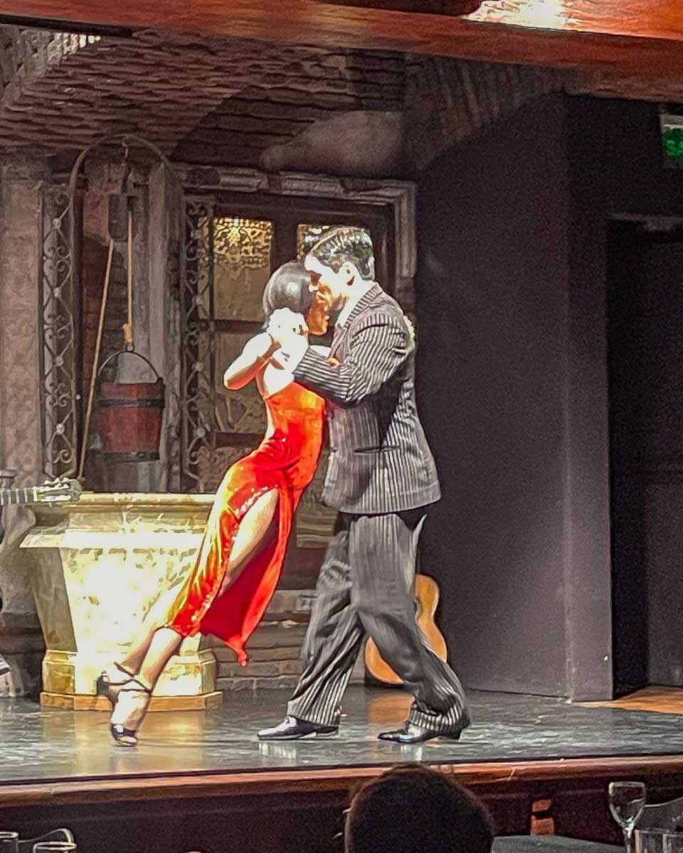 A woman in a red dress and a man tango at La Ventana Buenos Aires Argentina