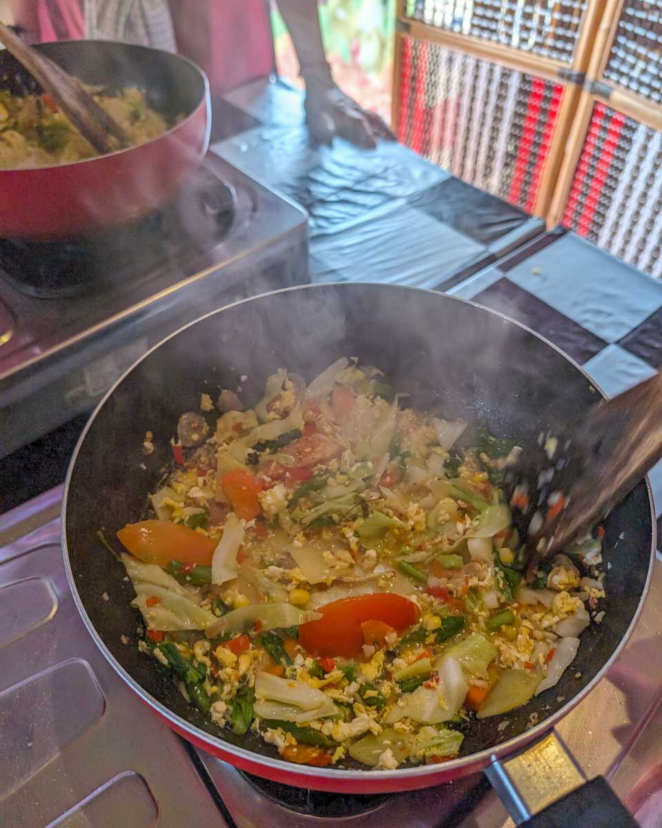 A pan cooking vegtables during a cooking class in Ubud Bali