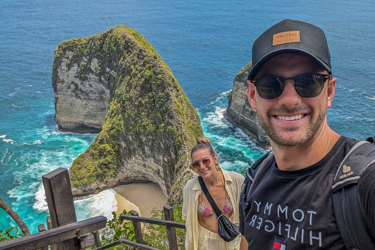 Bailey and Daniel on stairs looking down at Kelingking Beach on a Nusa Penida tour in Bali