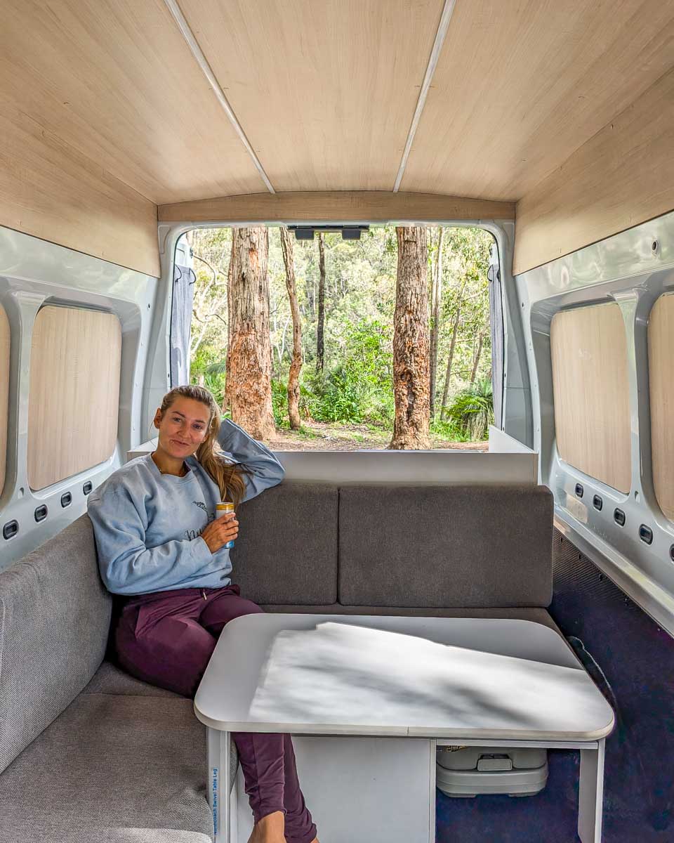 Bailey relaxes in the back of a JUCY campervan while in the woods of Australia