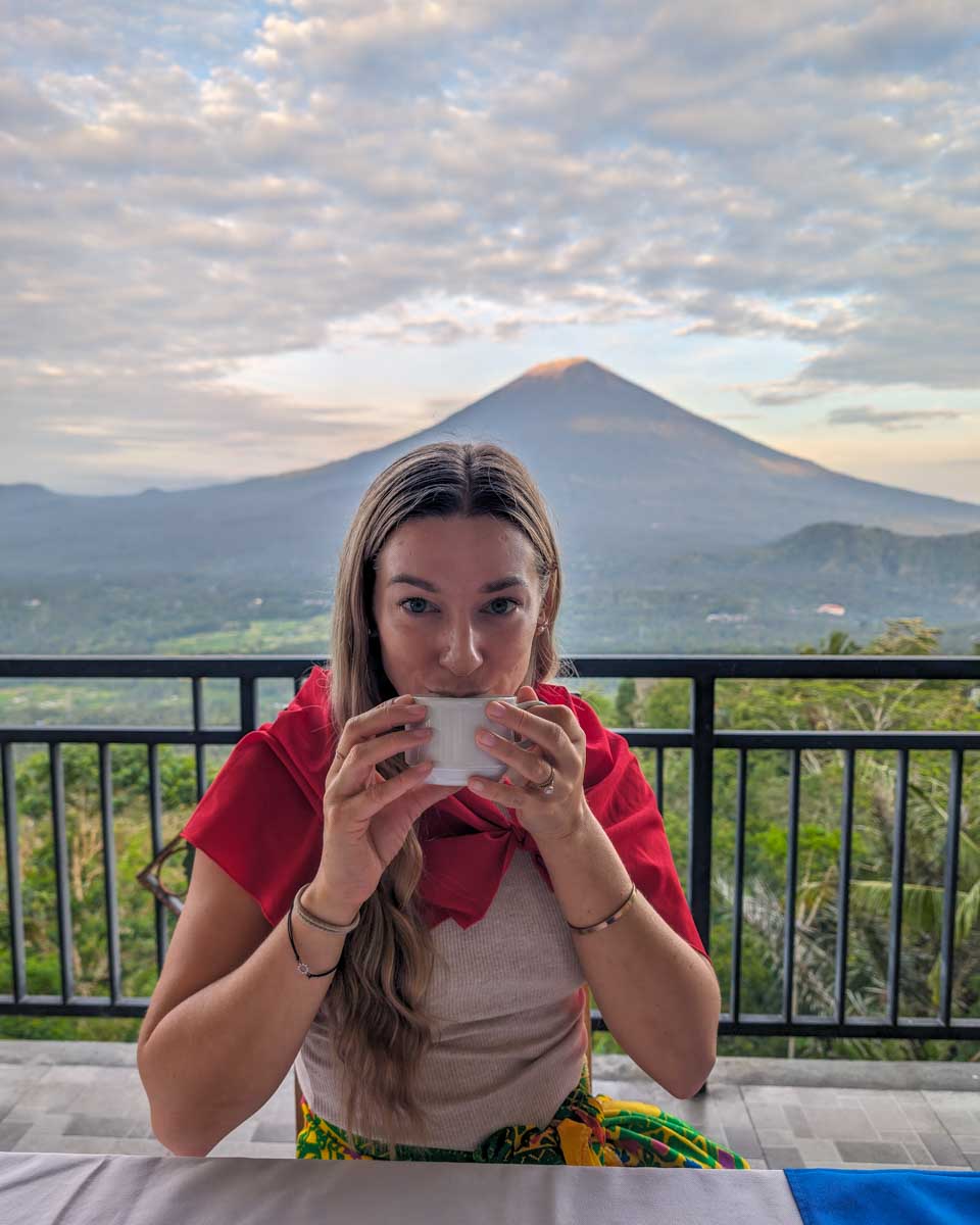 Bailey sips coffee with Mount Agung in the background at Lempuyang temple Bali