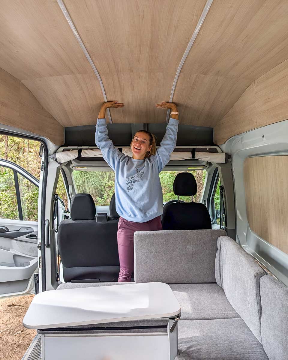 Bailey standing in a JUCY campervan while camping in Australia