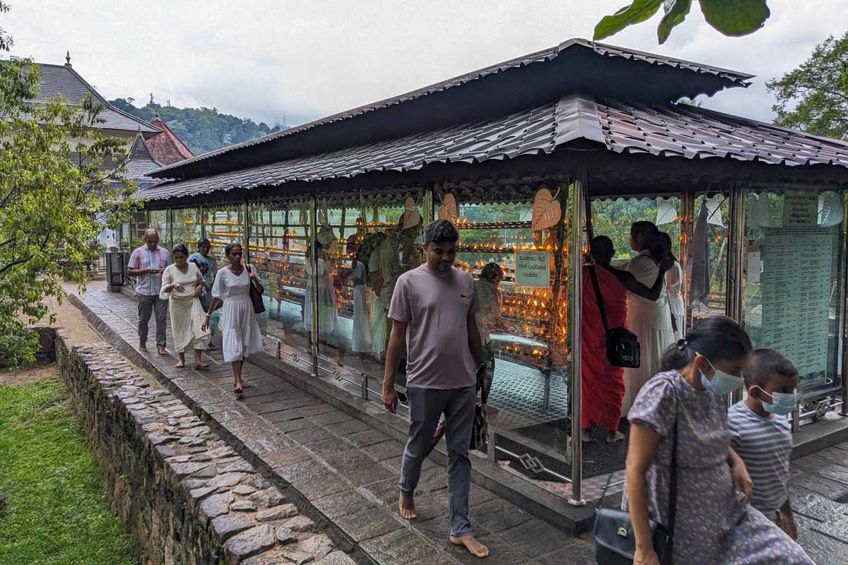 People at a shrine outside of the Sacred Tooth Temple in Kandy Sri Lanka