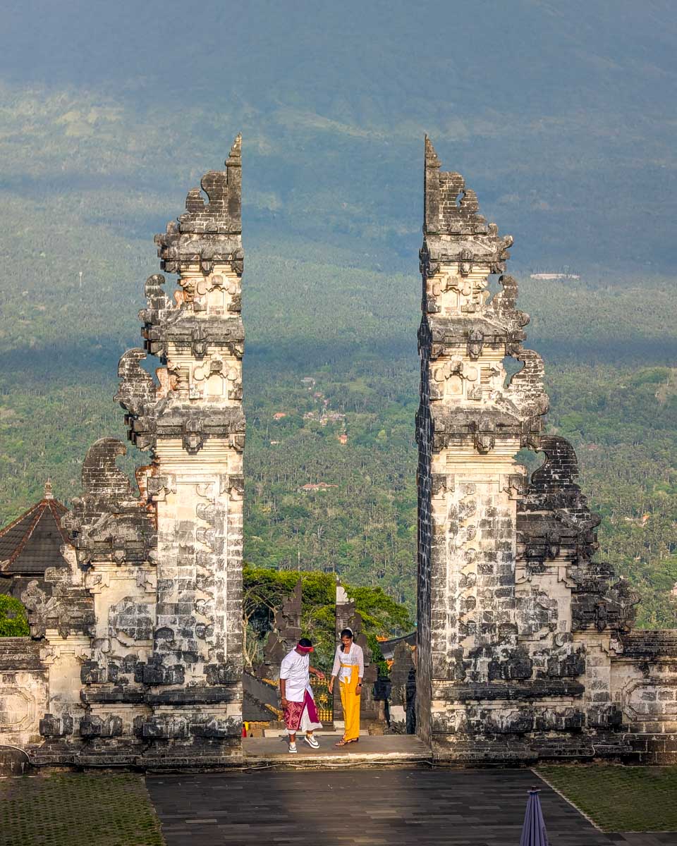 Two people stand at the gate of heaven at Lempuyang temple Bali