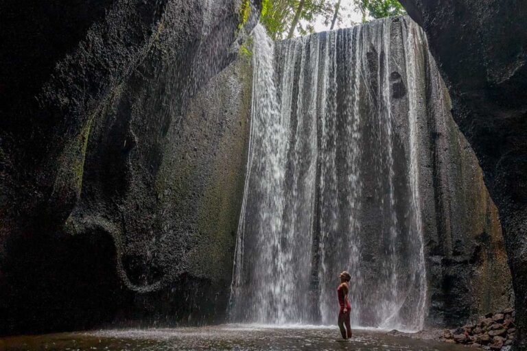Bailey stands at Tukad Cepung in Bali on a waterfall tour