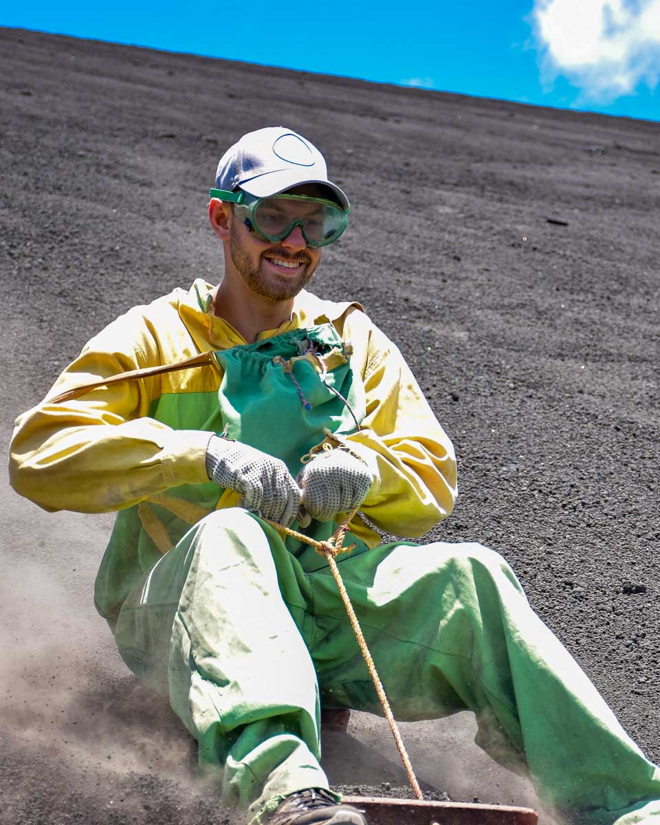 Daniel smiles coming down the cerro negro volcano boarding slope in Nicaragua