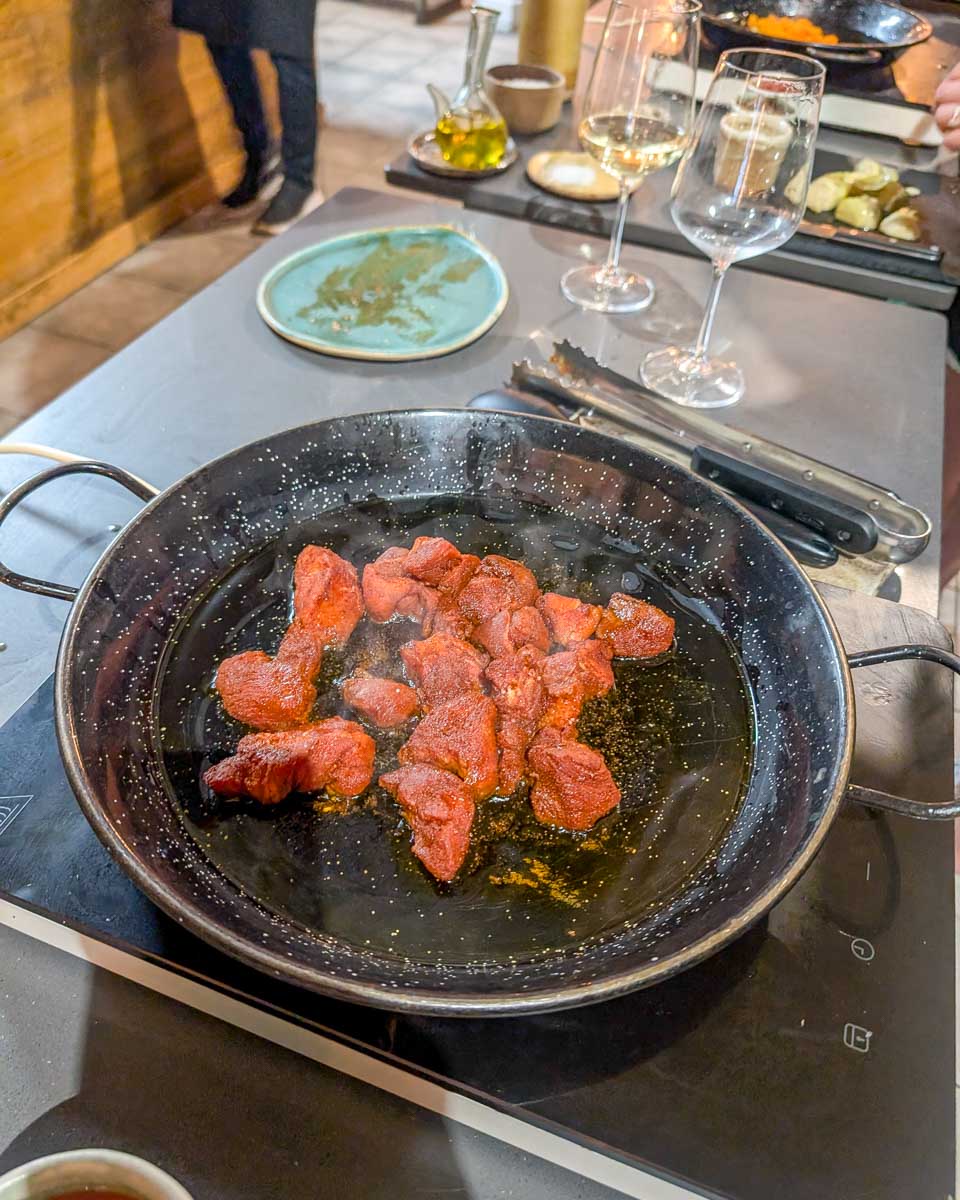Meat in a pan during a Paella making class in Barcelona Spain