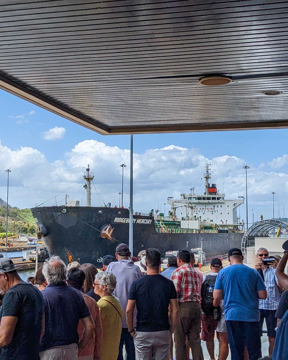 People watch a ship come down the Panama Canal in Panama City Panama
