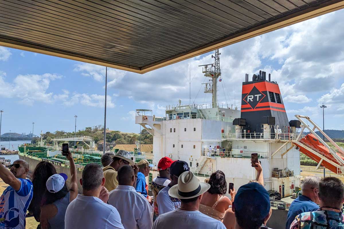 People watch a ship go by the Panama Canal in Panama City Panama