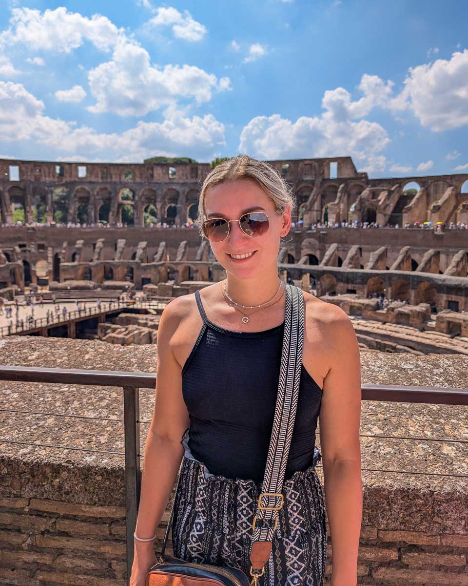 Bailey smiles and stands in the colosseum in Rome Italy