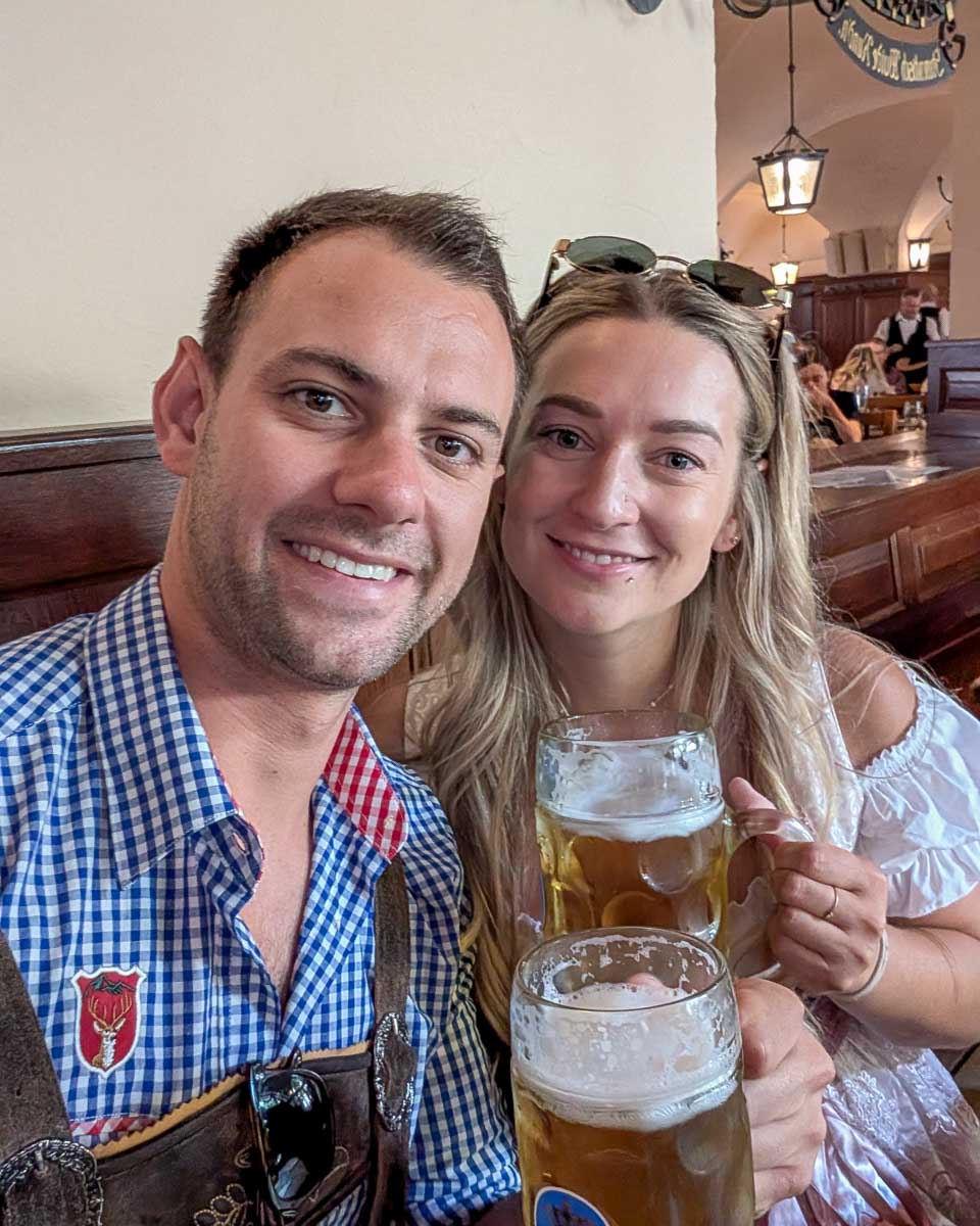 Daniel and Bailey smile and drink beer in a bar in Munich Germany