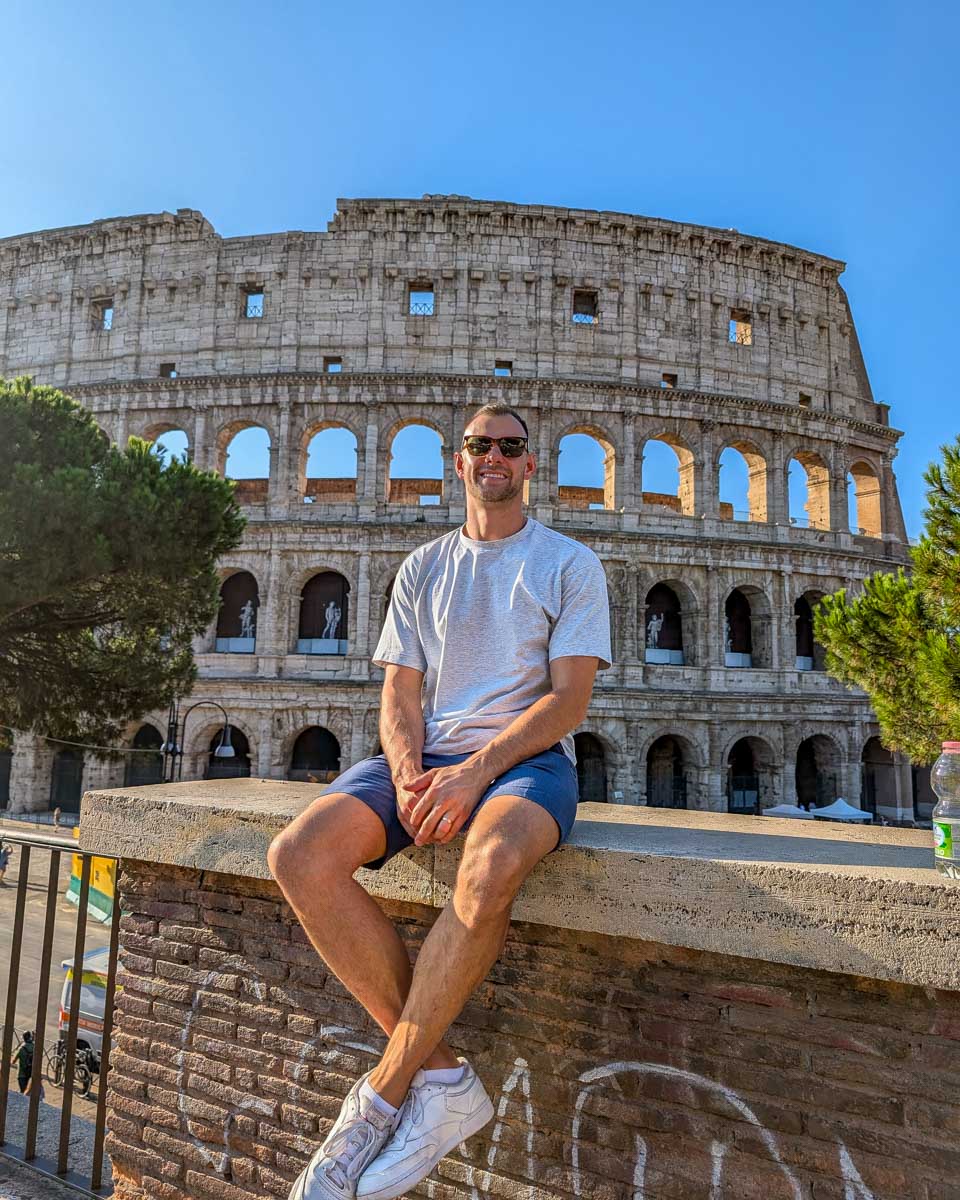 Daniel sitting outside of the colosseum in Rome Italy