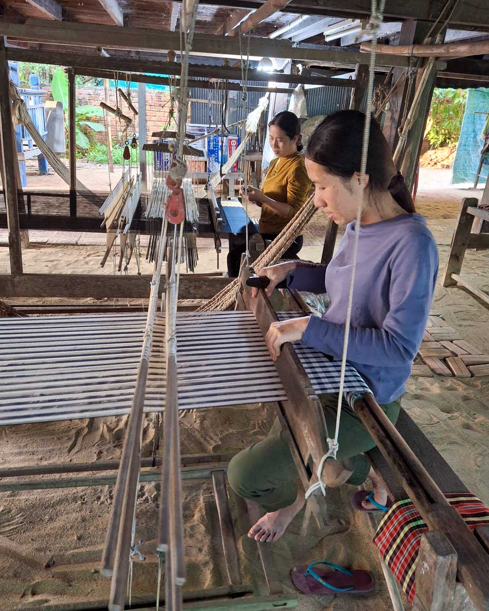 A woman makes a silk scarf on a tour from Phnom Penh Cambodia