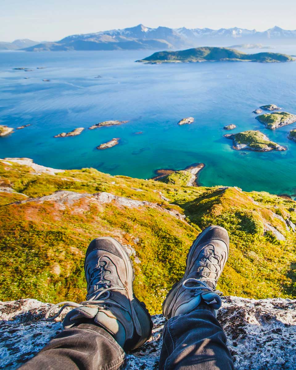 Two people sit on a summer hike from Tromso Norway