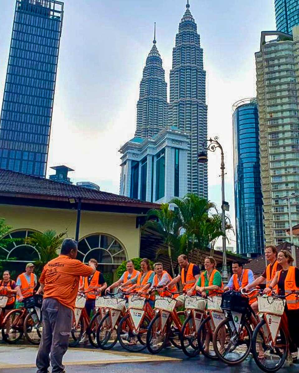 MikeBikes people listen to a guide and ride bikes in Kuala Lumpur on a tour in Malaysia 2
