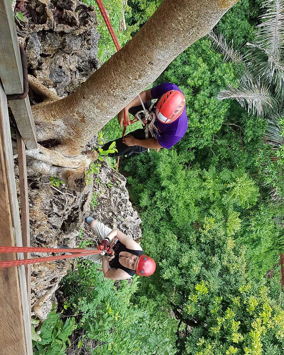 Thai'd Up Adventures people climb down a cliff in Krabi Thailand