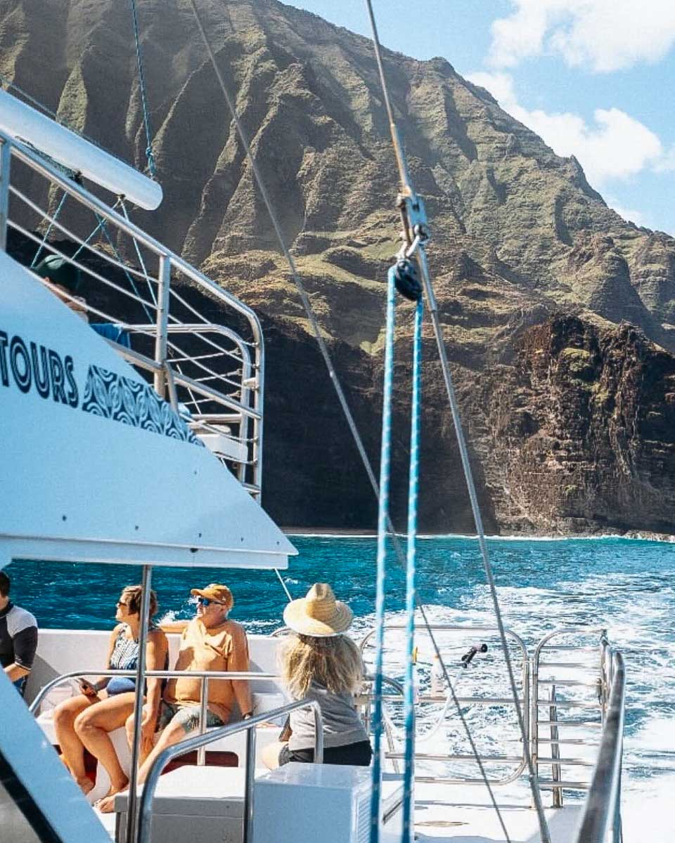 A catamaran sailing along the Na Pali Coast in Kauai Hawaii