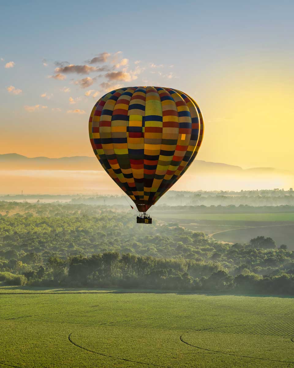 A hot air balloon flies over magaliesburg on a tour from Johannesburg South Africa